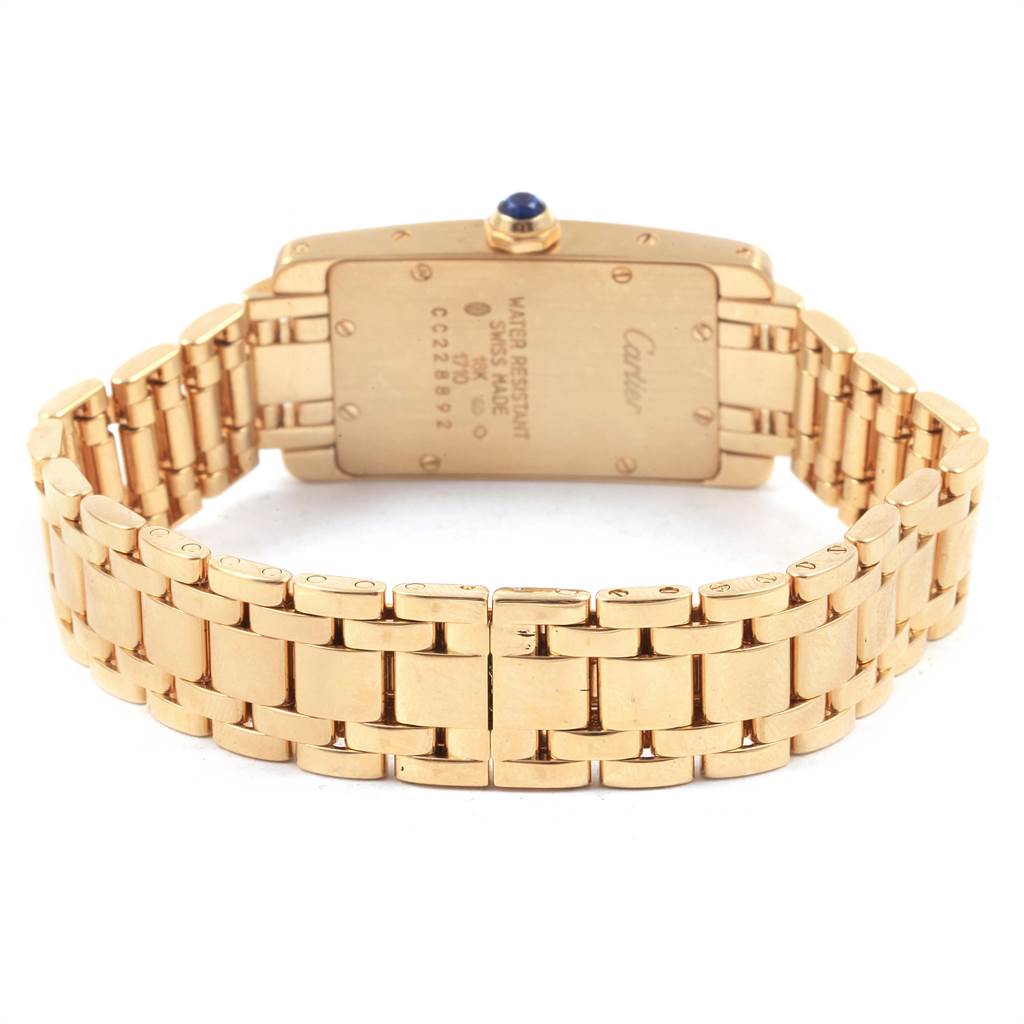 The image shows the back view of a Cartier Tank Américaine watch, highlighting the case back and gold bracelet.