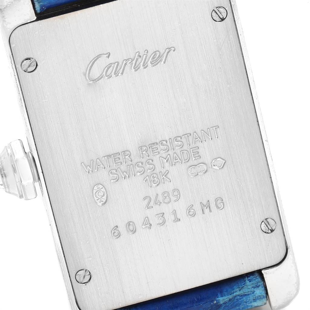 This image shows the back case of a Cartier Tank Américaine watch, displaying engravings and screws.