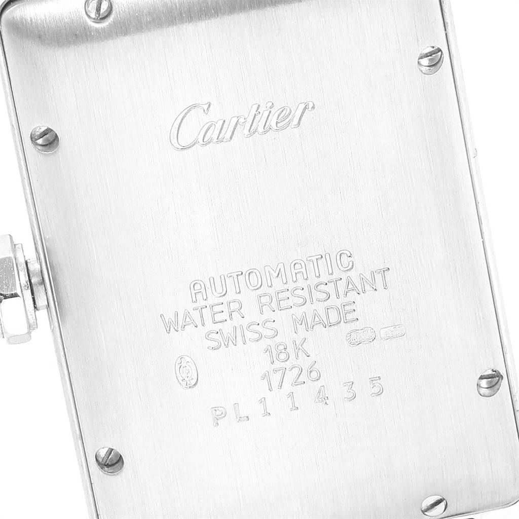The image shows the back of a Tank Americaine model by Cartier, highlighting its engraved specifications.