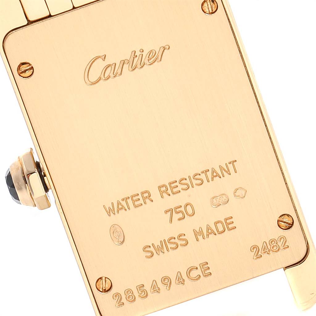 The image shows the back plate and part of the crown of a Cartier Tank Americaine W26015K2 Women's Yellow Gold Silver Dial W26015K2 Women's Yellow Gold Silver Dial watch at a slight angle.