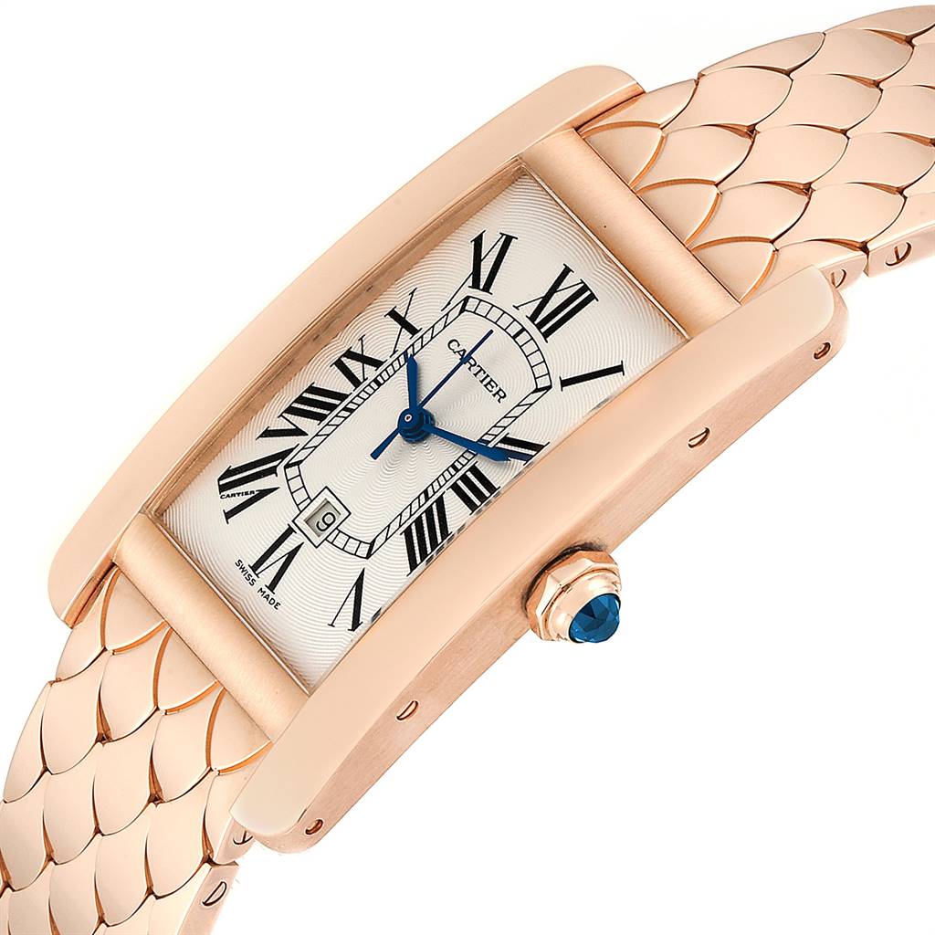 The image shows a top angled view of the Cartier Tank Américaine watch, highlighting its rectangular face, Roman numeral dial, and metal strap.