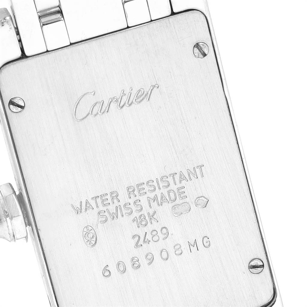 This close-up shows the back case of a Tank Americaine model by Cartier, including the engravings and a portion of the bracelet.