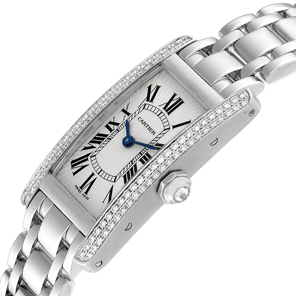 The Cartier Tank Americaine WB7018L1 Women's White Gold Silver Dial WB7018L1 Women's White Gold Silver Dial watch is shown at an angle featuring the face, bezel with diamonds, and part of the bracelet band.
