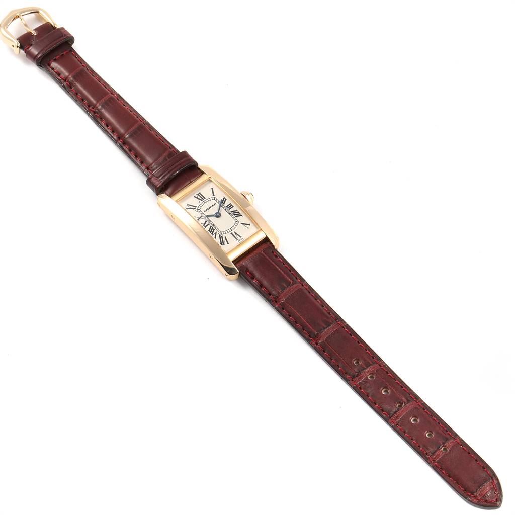 The Cartier Tank Américaine watch is shown from a top-down angle, displaying its rectangular dial and leather strap.
