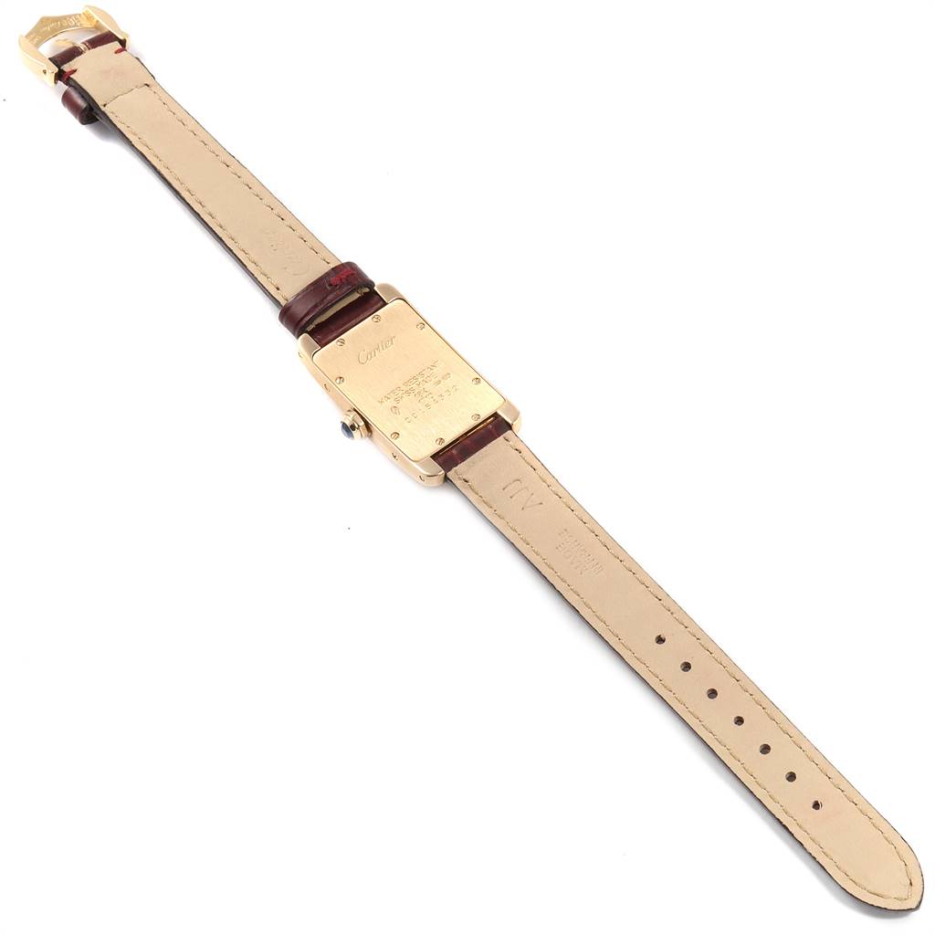 The image shows the back and strap of a Cartier Tank Americaine W2601556 Women's Yellow Gold Silver Dial W2601556 Women's Yellow Gold Silver Dial watch from a top-down angle.