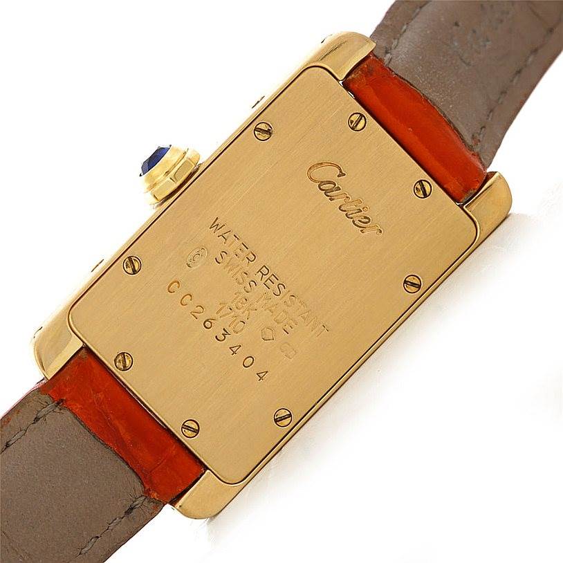 The image shows the back case and part of the strap of a Tank Americaine watch by Cartier.
