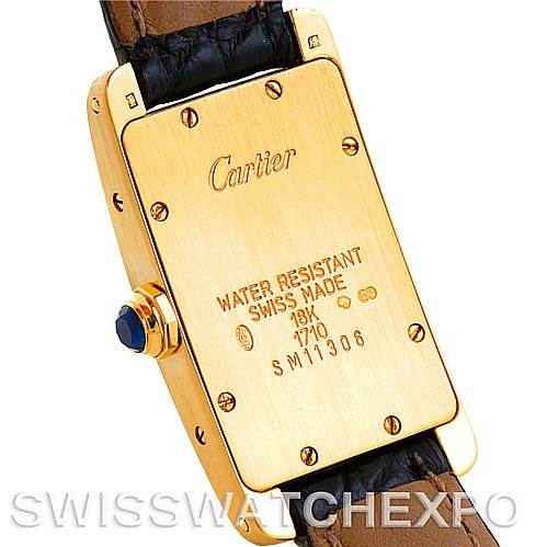 This image shows the back case and a portion of the strap of the Cartier Tank Americaine W2601956 Women's Yellow Gold Silver Dial W2601956 Women's Yellow Gold Silver Dial watch, featuring engraved details.