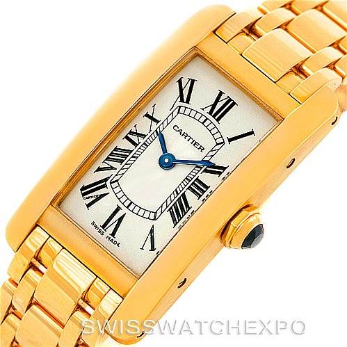 This image shows a Cartier Tank Americaine W26015K2 Women's Yellow Gold Silver Dial W26015K2 Women's Yellow Gold Silver Dial watch at an angle displaying the face, gold casing, and part of the bracelet band.