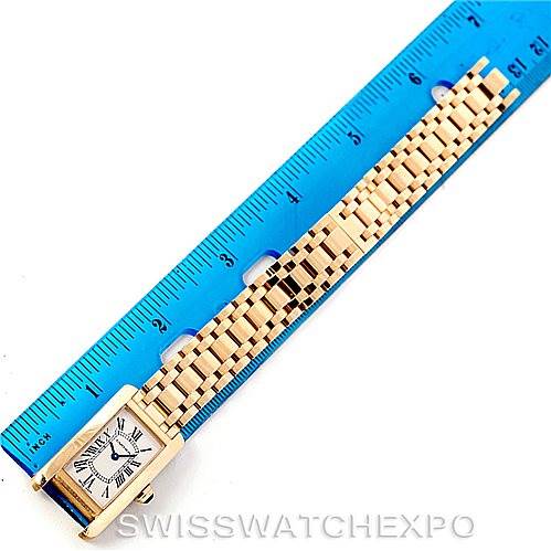 The image shows a top-down view of the Cartier Tank Americaine W26015K2 Women's Yellow Gold Silver Dial W26015K2 Women's Yellow Gold Silver Dial watch with a ruler measuring its length.