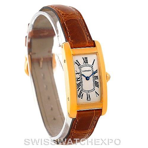This image shows a Cartier Tank Americaine W2601956 Women's Yellow Gold Silver Dial W2601956 Women's Yellow Gold Silver Dial watch at an angled side view, highlighting its rectangular gold case and brown leather strap.