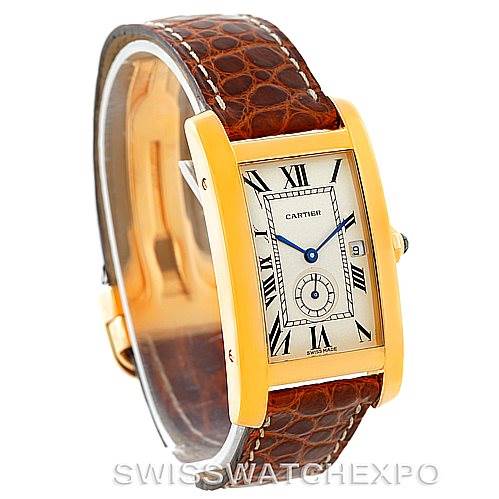 The image shows a Cartier Tank Américaine watch at a slight angle, highlighting its rectangular gold case, brown leather strap, and Roman numeral dial.