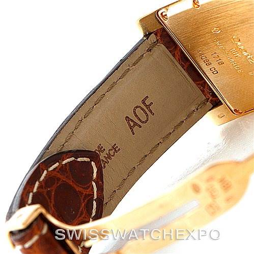 The image shows the back of a Cartier Tank Americaine W2600351 Women's Yellow Gold Silver Dial W2600351 Women's Yellow Gold Silver Dial watch and part of the strap with engraved details and markings.
