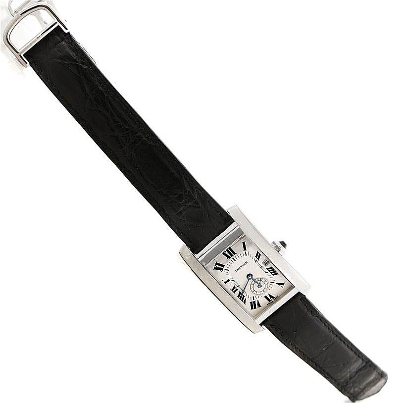 The image shows a Cartier Tank Americaine Women
s White Gold Silver Dial Women
s White Gold Silver Dial watch from a top-down angle, highlighting its rectangular face and black leather strap.