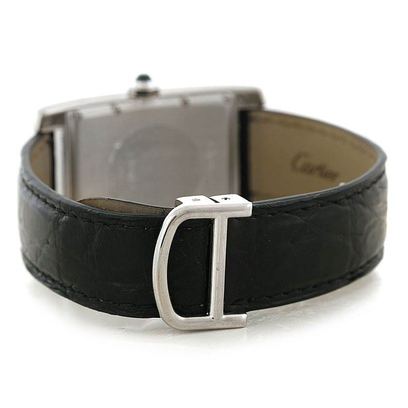 The image shows the back view of the Cartier Tank Americaine Women
s White Gold Silver Dial Women
s White Gold Silver Dial watch, focusing on its clasp and leather strap.