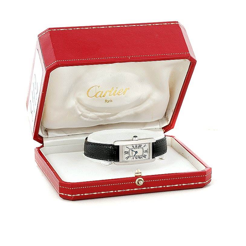 The Cartier Tank Americaine W2601956 Women
s White Gold Silver Dial W2601956 Women
s White Gold Silver Dial watch is displayed frontally inside its open red and white box.