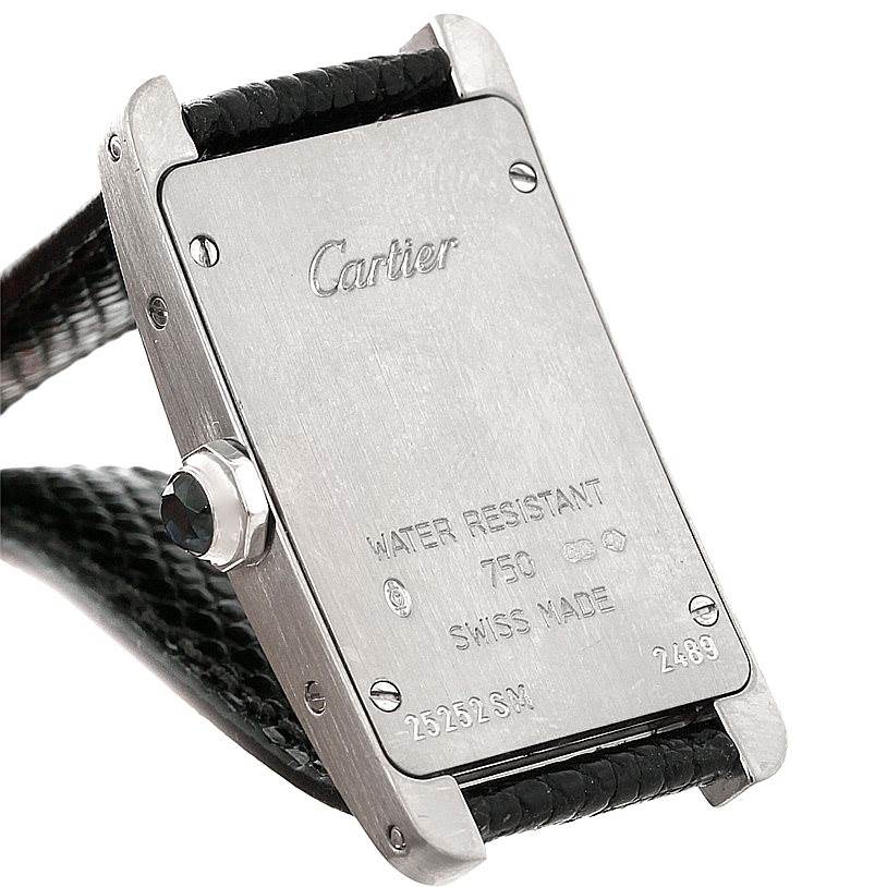 The image shows the back view of a Cartier Tank Américaine watch, highlighting its engraving, case, and strap attachment.
