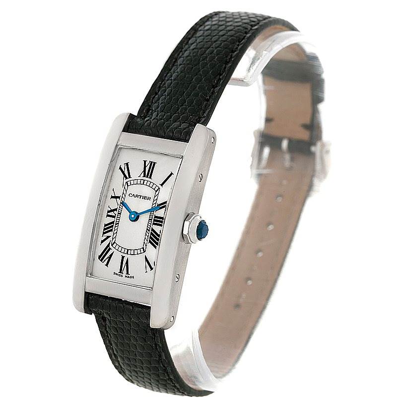 The image shows a Cartier Tank Americaine W2601956 Women
s White Gold Silver Dial W2601956 Women
s White Gold Silver Dial watch at a three-quarter angle, highlighting the face, case, crown, and black leather strap.