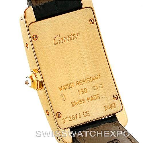 This image shows the back of a Cartier Tank Americaine W2601956 Women's Yellow Gold Silver Dial W2601956 Women's Yellow Gold Silver Dial watch, including inscriptions and the crown with a cabochon detail.