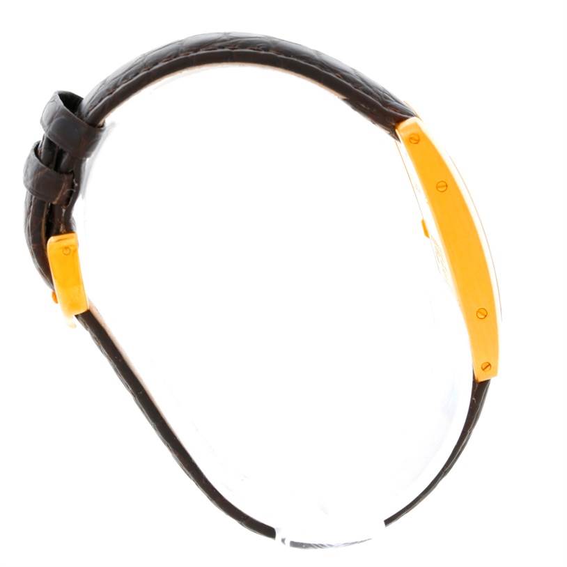 The Cartier Tank Americaine W2601956 Women's Yellow Gold Silver Dial W2601956 Women's Yellow Gold Silver Dial watch is shown from a side angle, highlighting its gold case and brown leather strap.