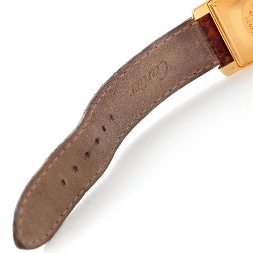 The image shows a close-up of the leather strap and part of the back case of a Cartier Tank Americaine Women's Yellow Gold Silver Dial Women's Yellow Gold Silver Dial watch.