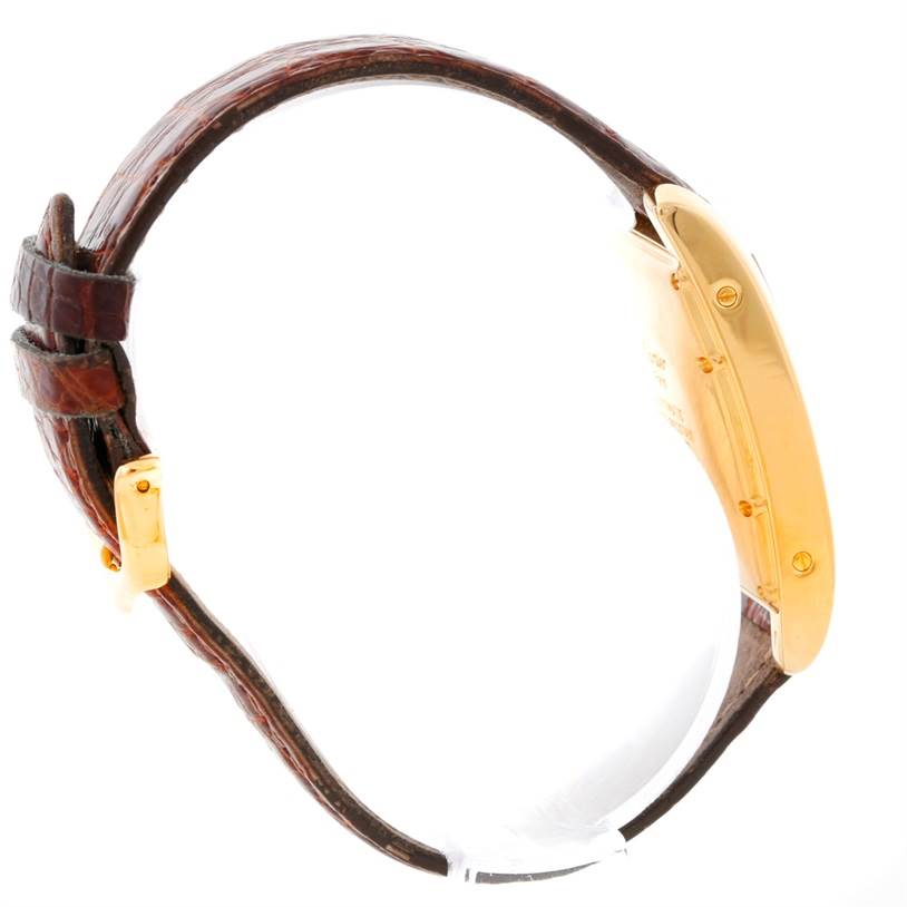 The image shows a side view of the Tank Americaine by Cartier, highlighting the watch's case and leather strap.