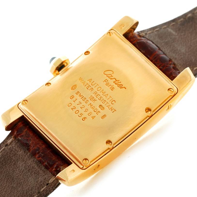 The image shows the back view of a Cartier Tank Americaine Women's Yellow Gold Silver Dial Women's Yellow Gold Silver Dial watch, highlighting the gold case and brown leather strap.