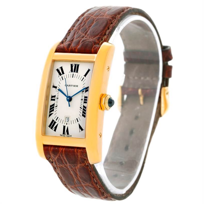 The Cartier Tank Americaine Women's Yellow Gold Silver Dial Women's Yellow Gold Silver Dial watch is shown at an angle displaying its rectangular face, gold case, brown leather strap, and crown with a blue cabochon.