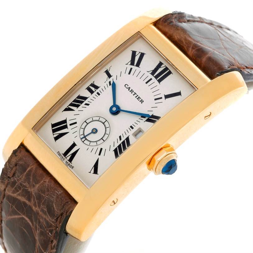 This image shows a close-up angled view of a Cartier Tank Americaine W2600351 Yellow Gold Silver Dial W2600351 Yellow Gold Silver Dial watch, highlighting its dial, crown, and leather strap.