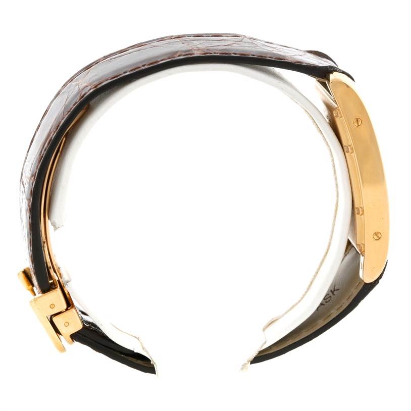 This is a side view of the Cartier Tank Americaine W2600351 Yellow Gold Silver Dial W2600351 Yellow Gold Silver Dial watch showing the strap and gold case.