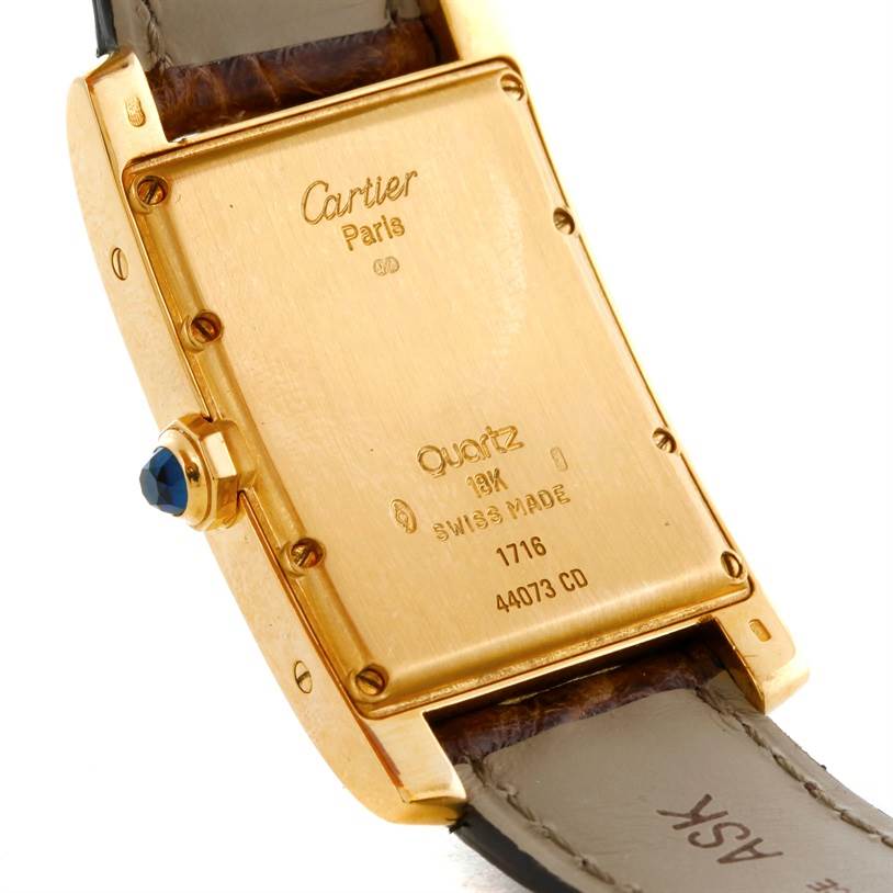 The image shows the back case and side of the Cartier Tank Americaine W2600351 Yellow Gold Silver Dial W2600351 Yellow Gold Silver Dial watch, including the strap and crown.