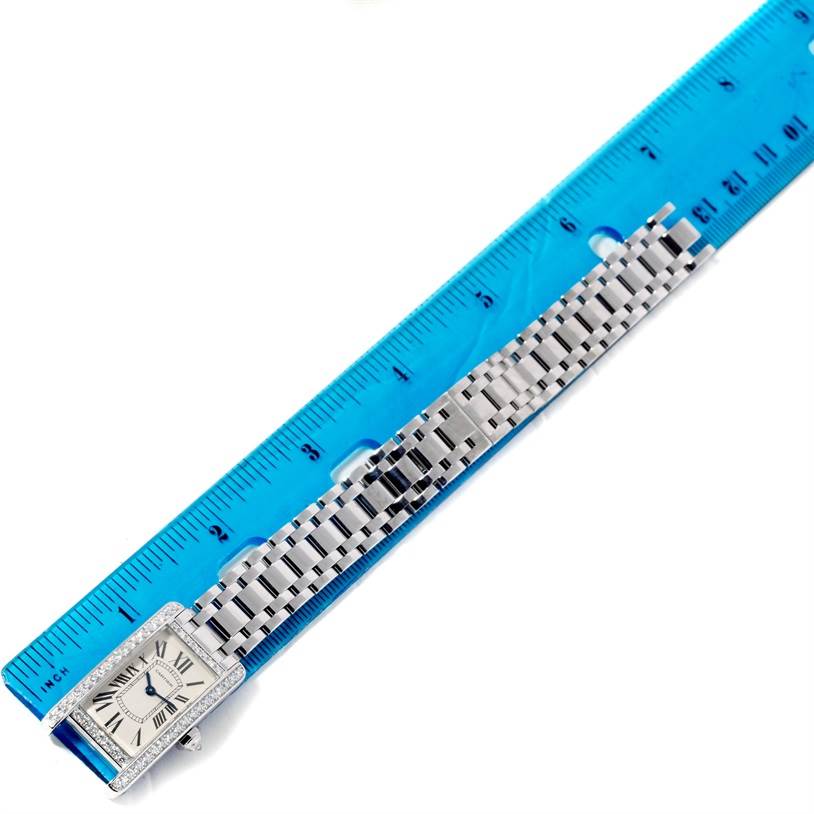 The Cartier Tank Americaine WB707331 Women
s White Gold Silver Dial WB707331 Women
s White Gold Silver Dial watch is shown from a top angle, displaying the face and metal bracelet alongside a ruler for scale.