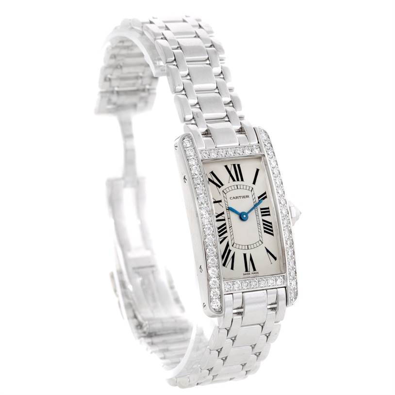 The image shows a Cartier Tank Americaine WB707331 Women
s White Gold Silver Dial WB707331 Women
s White Gold Silver Dial watch from a front-left angle, highlighting its face, bracelet, and diamond-encrusted bezel.