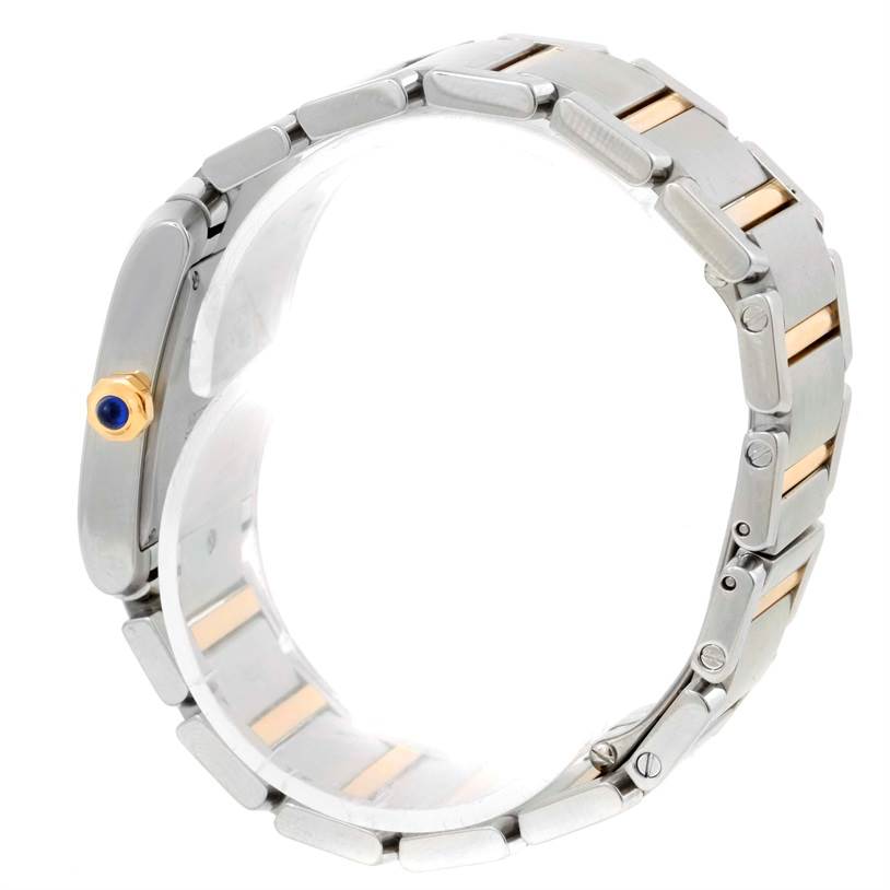 The image shows a side view of the Cartier Tank Française watch, highlighting the bracelet and the crown with a blue cabochon.