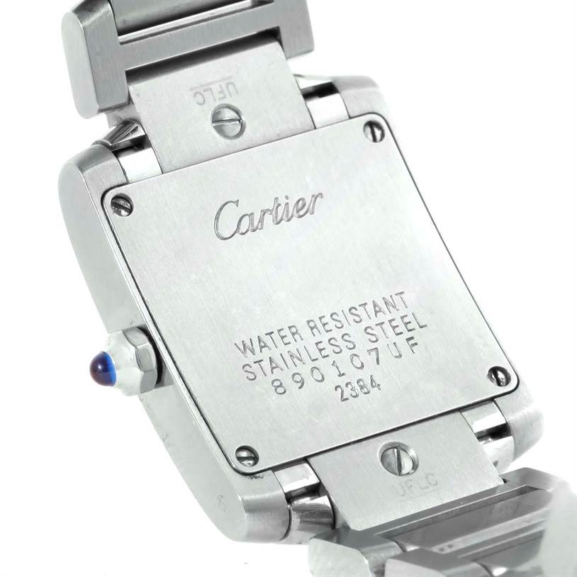 The image shows the back and partially open clasp of a Cartier Tank Française watch, revealing the engraving details.