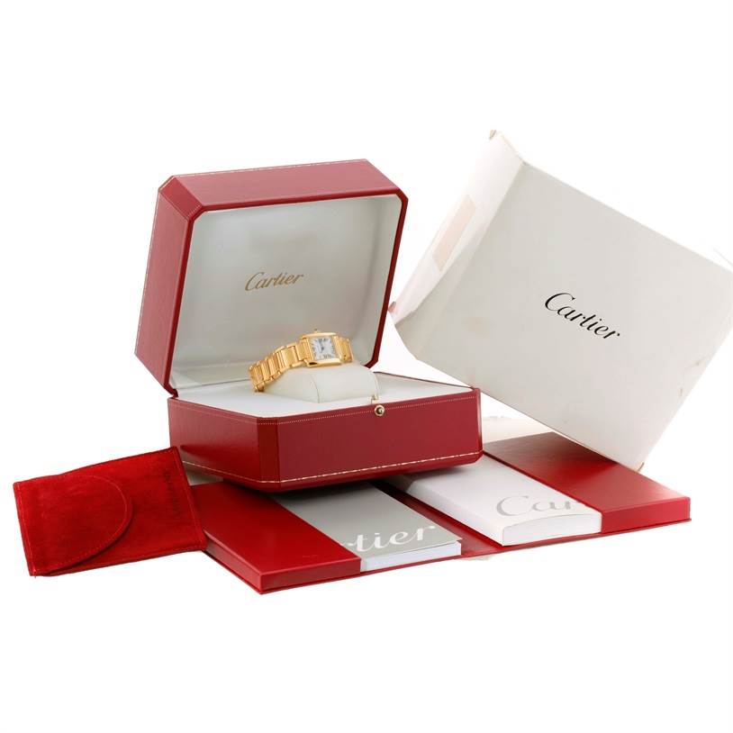The image shows the Cartier Tank Francaise W50002N2 Women's Yellow Gold Silver Dial W50002N2 Women's Yellow Gold Silver Dial watch in its open red box, with additional packaging and booklets around it.