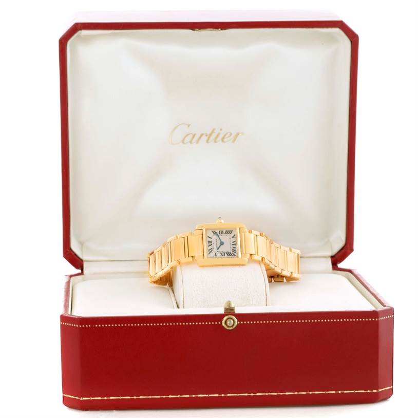 The Cartier Tank Française watch is displayed front-on in its red box with the brand's logo behind.