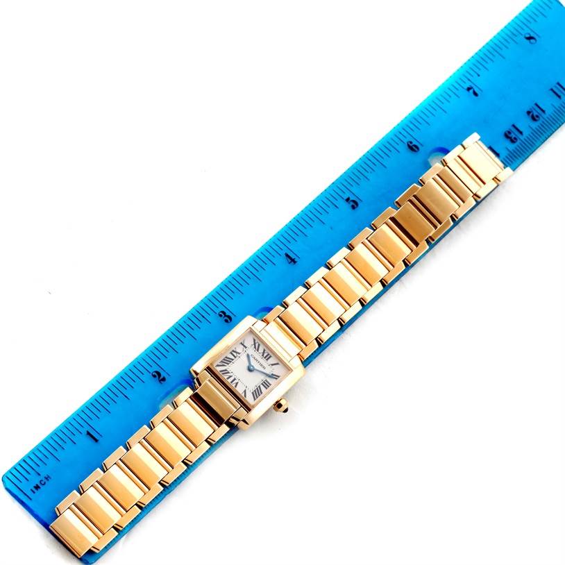 The Cartier Tank Francaise W50002N2 Women's Yellow Gold Silver Dial W50002N2 Women's Yellow Gold Silver Dial watch is shown laid flat next to a ruler, displaying the face and entire bracelet.