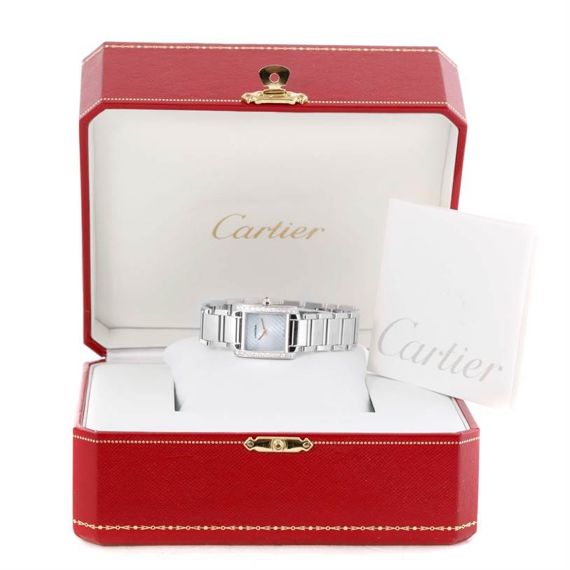 A Cartier Tank Francaise WE1002S3 Women's White Gold Blue Dial WE1002S3 Women's White Gold Blue Dial watch is displayed inside an open red Cartier box with a booklet beside it.