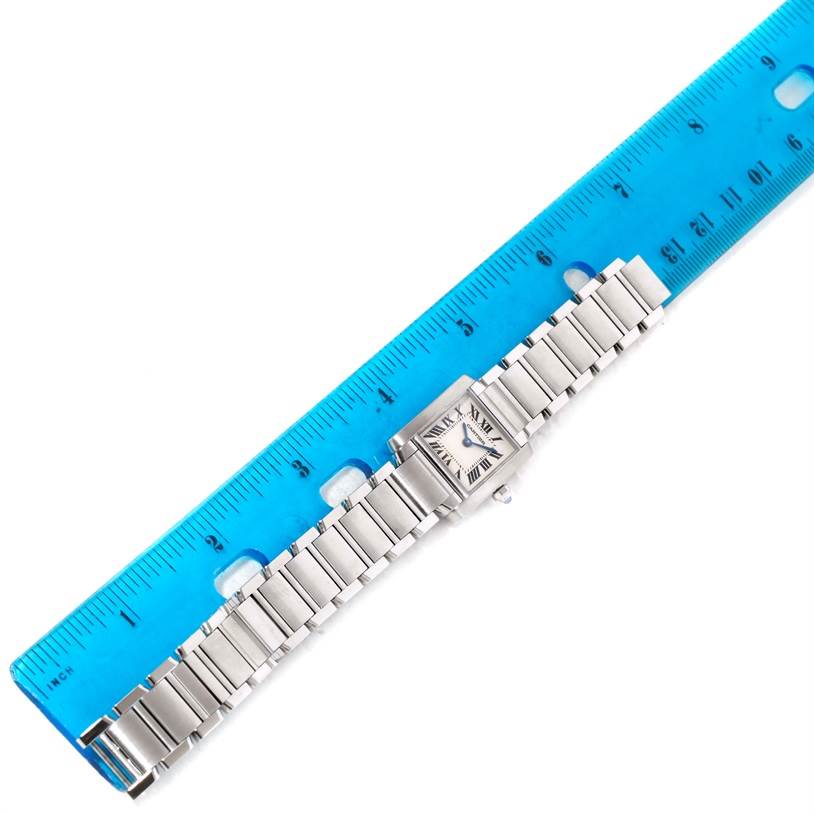 The image shows a Cartier Tank Francaise W51008Q3 Women's Stainless Steel Silver Dial W51008Q3 Women's Stainless Steel Silver Dial watch placed alongside a blue ruler for measurement.