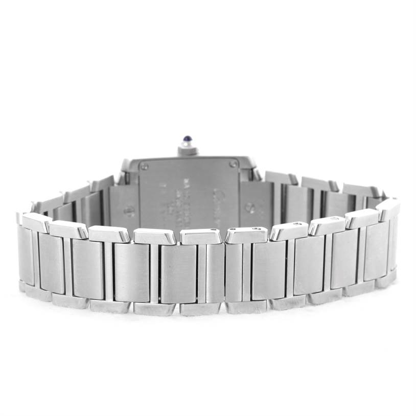 The image shows the back view of a Cartier Tank Française watch, highlighting its stainless steel bracelet and case back.