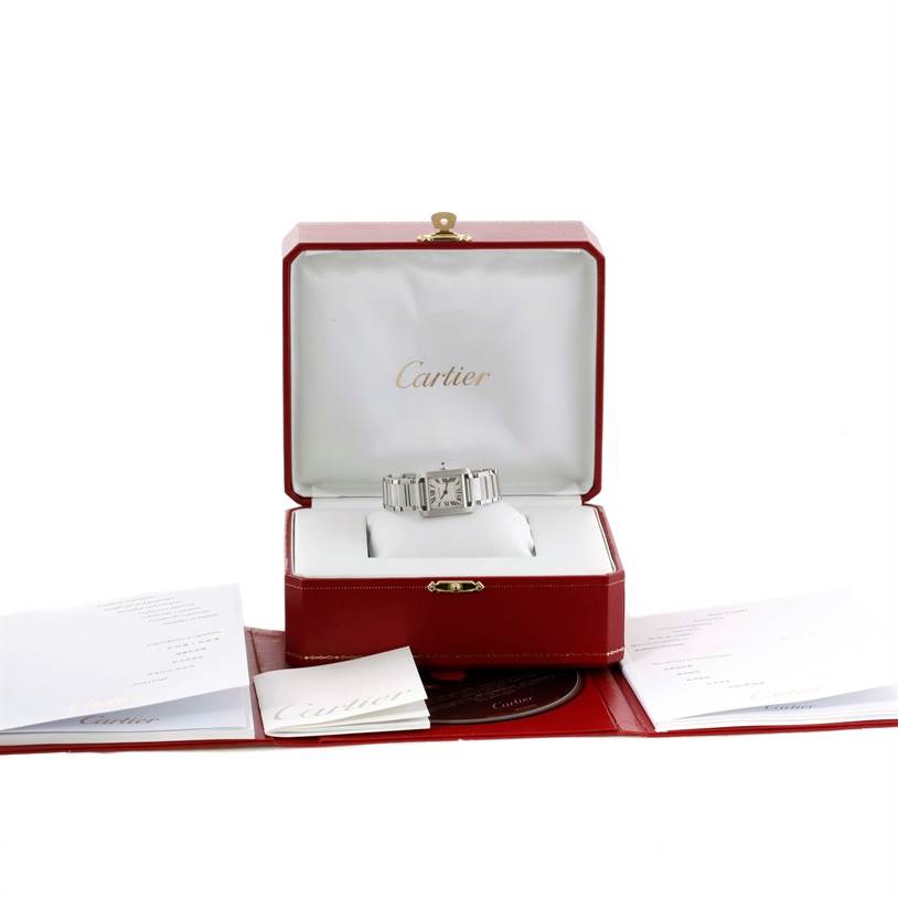 The Cartier Tank Française watch is displayed in its box with accompanying papers laid out in front.