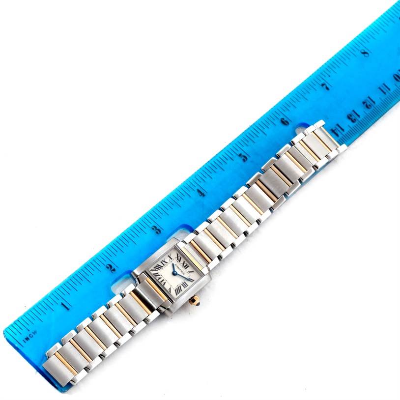 The image shows a Cartier Tank Francaise W51007Q4 Women's Steel and Gold (two tone) Silver Dial W51007Q4 Women's Steel and Gold (two tone) Silver Dial watch with a metal band, placed next to a blue ruler for size reference.