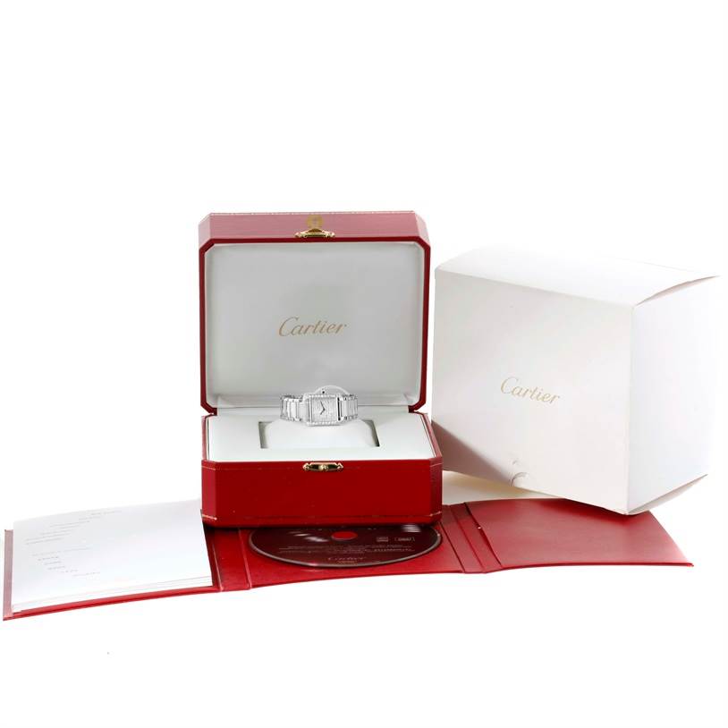The image shows a Cartier Tank Francaise WE1002S3 Women's White Gold Silver Dial WE1002S3 Women's White Gold Silver Dial watch displayed inside its open red box, surrounded by packaging and accessories.