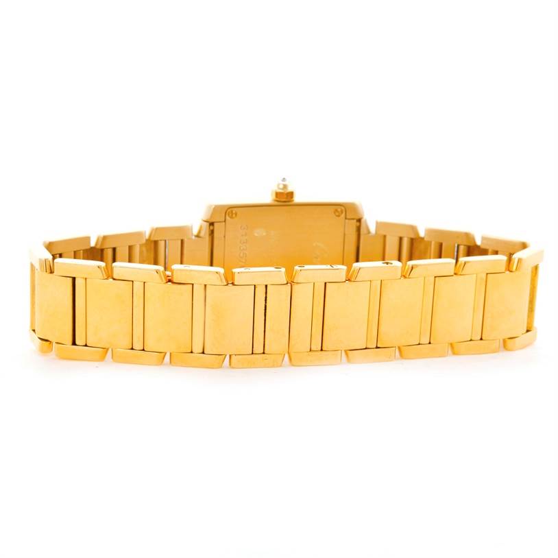 The image shows the back of the Tank Francaise watch by Cartier, highlighting its gold bracelet and case.