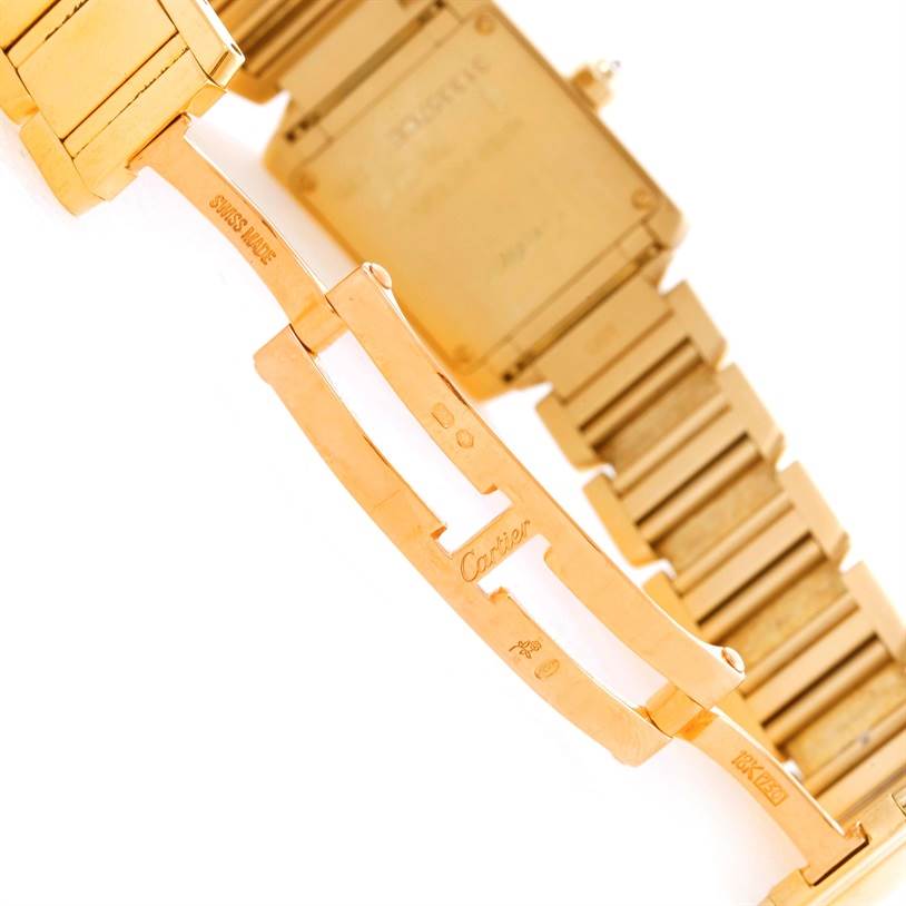 The image shows the clasp and backside of the Cartier Tank Française watch, highlighting the gold metal bracelet and "Cartier" engraving.