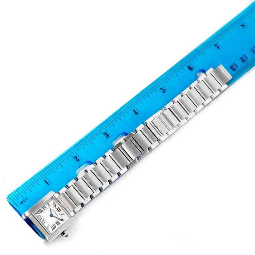 The image shows a side view of a Cartier Tank Française watch with the metal bracelet measured against a blue ruler.