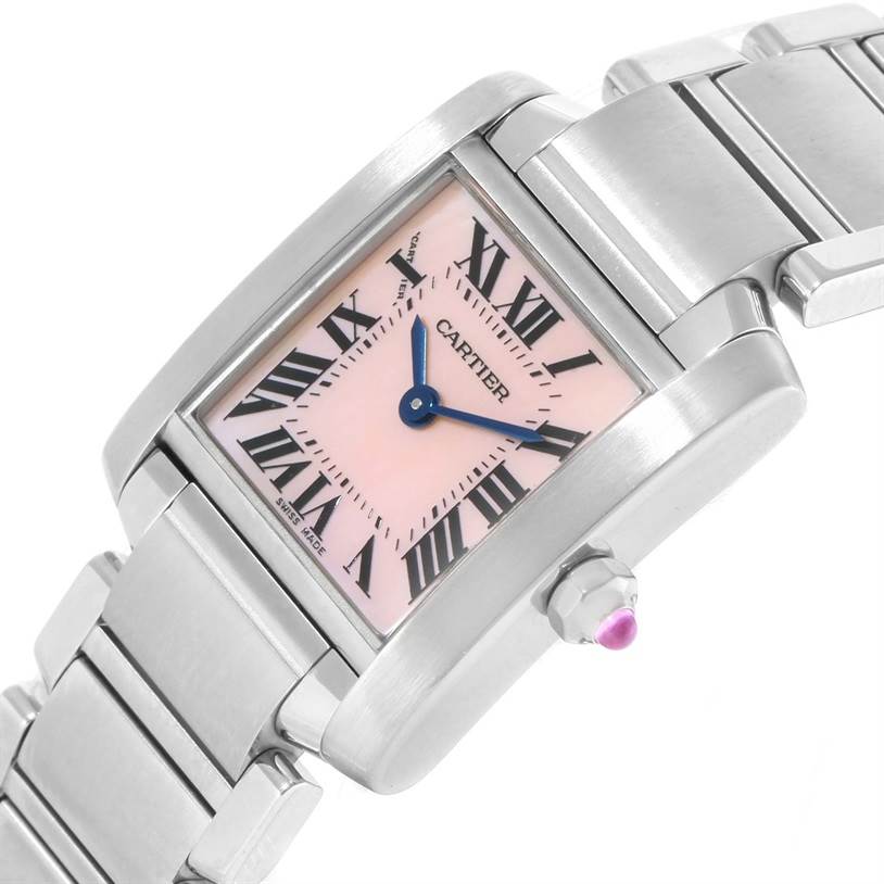 The image shows a close-up angle of a Cartier Tank Française watch highlighting its face, bracelet, and crown with a pink gemstone.