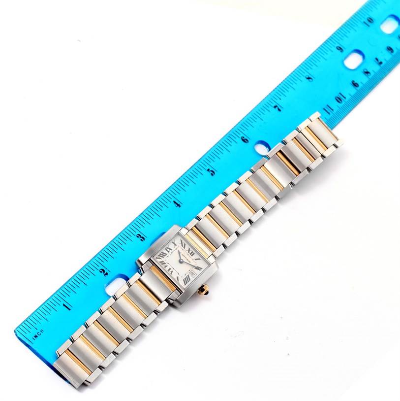 The image shows a top-down view of a Cartier Tank Francaise W51012Q4 Women's Steel and Gold (two tone) Silver Dial W51012Q4 Women's Steel and Gold (two tone) Silver Dial watch alongside a blue ruler for scale.