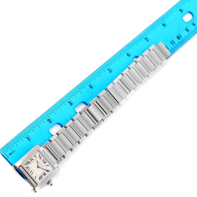 The image shows a Cartier Tank Francaise WSTA0005 Women's Stainless Steel Silver Dial WSTA0005 Women's Stainless Steel Silver Dial watch laid flat next to a ruler, highlighting its case and bracelet.