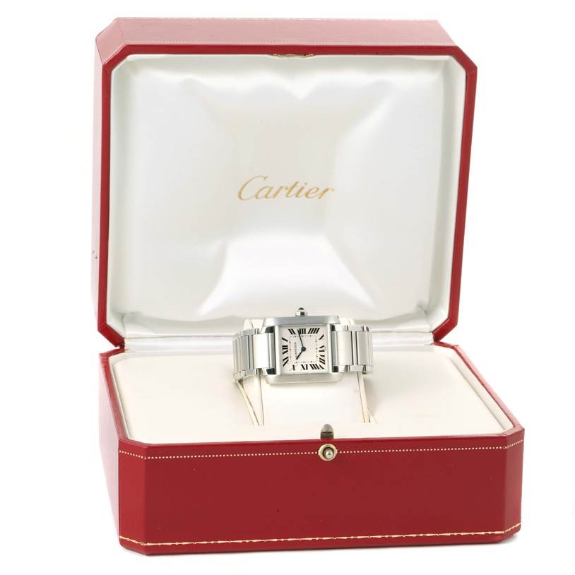 The photo shows a Cartier Tank Française watch displayed in its open red and white branded box, with the watch face and bracelet visible.
